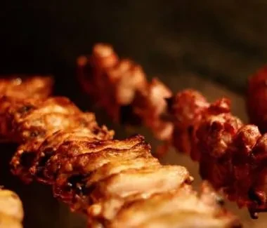 Several golden-brown skewers of roasted meat.