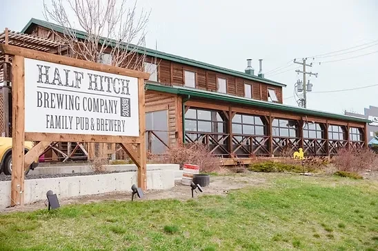 Half Hitch Brewing Company's rustic log building and covered porch.