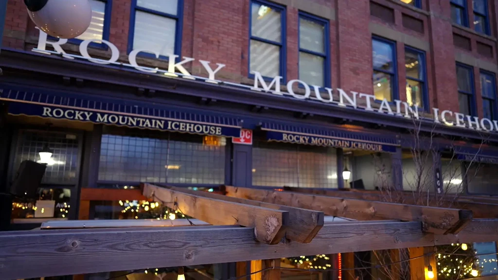 Rocky Mountain Icehouse at night with red brick and string-lit patio.
