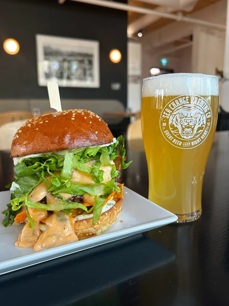 Gourmet burger and a pint of Sea Change Brewing Co. beer.