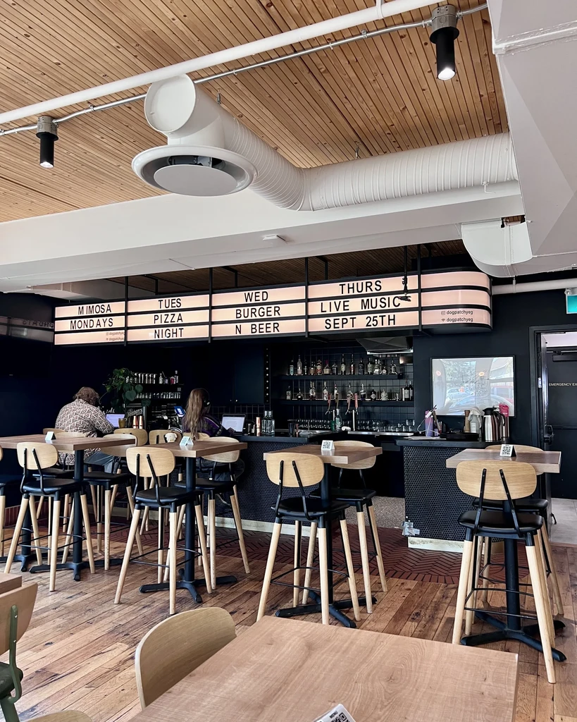 Restaurant bar interior with illuminated specials sign and seated customers.
