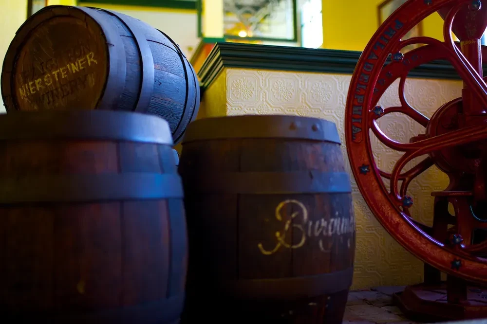 Wooden wine barrels, one Niersteiner, and antique Philadelphia red wheel.