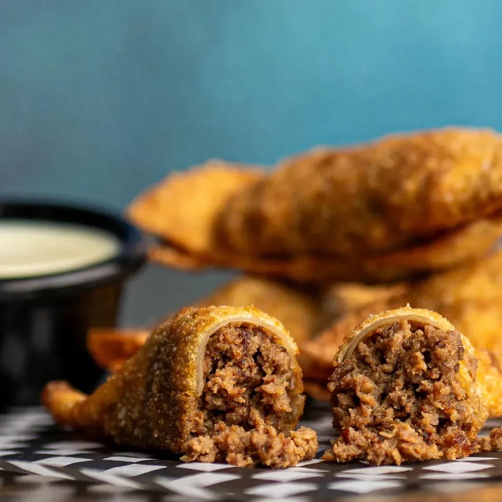 Crispy deep-fried rolls with minced meat filling and dipping sauce.