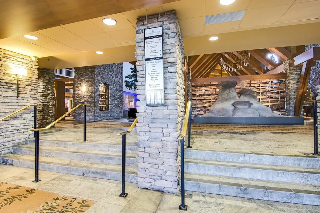 Stone and wood lodge lobby with a backlit directory sign.