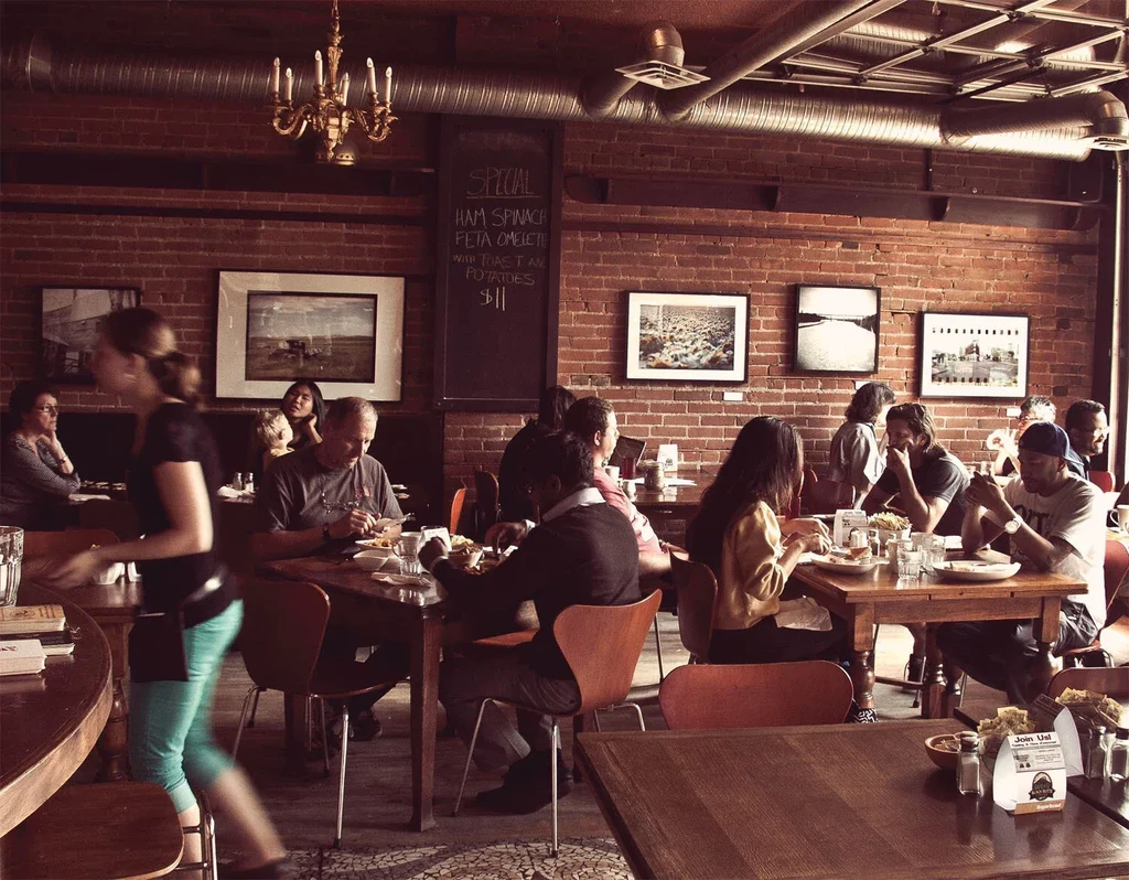 Warm, rustic-industrial restaurant interior with patrons.