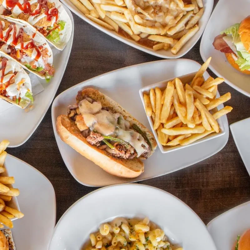 Top-down view of tacos, sub, fries, burger, and mac and cheese.