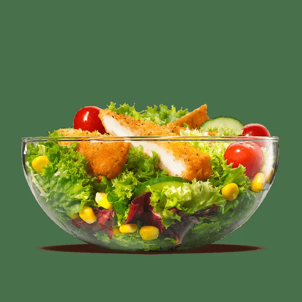 Salad bowl with fried chicken tenders, lettuce, tomatoes, cucumber, corn.
