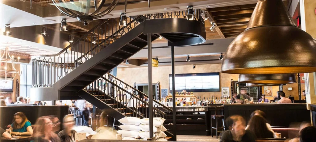 Lively multi-level restaurant interior with a bar and staircase.
