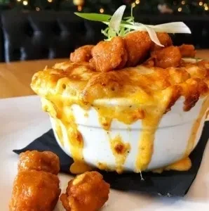 Close-up of baked mac and cheese, bubbling cheese, and crispy fried food.