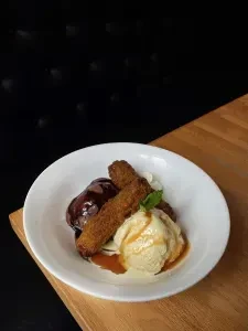Top-down: Fried dessert, two ice creams, whipped cream, and mint.