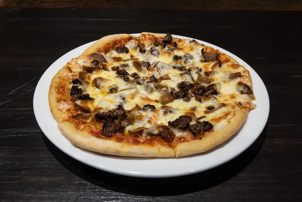 Pizza with two distinct meats, bubbly mozzarella, and red sauce.