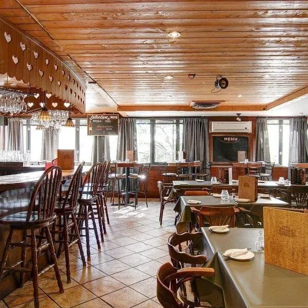 Rustic restaurant and bar interior with a wooden bar and dining tables.