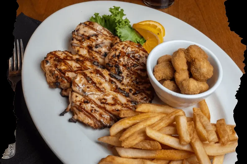 Grilled chicken, french fries, and fried bites on an oval plate.