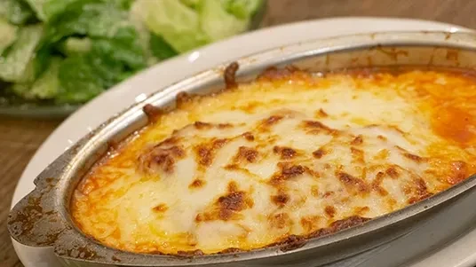 Bubbly, golden-brown baked lasagna or cheesy pasta in a rustic dish.