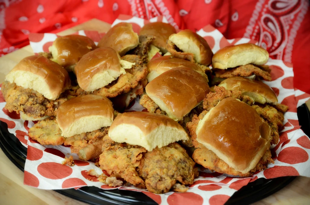 Crispy fried chicken sliders on a red polka dot napkin.