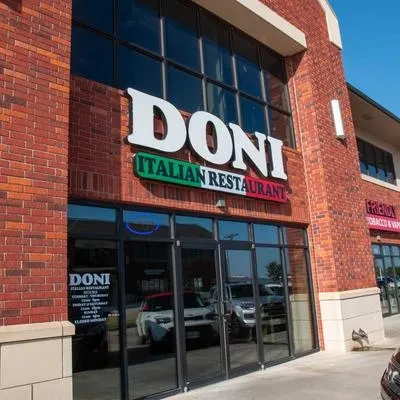 Exterior of Doni Italian Restaurant, a red brick building with large glass windows.
