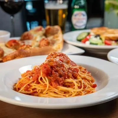 Plate of spaghetti with meatballs, rich tomato sauce, and grated cheese.