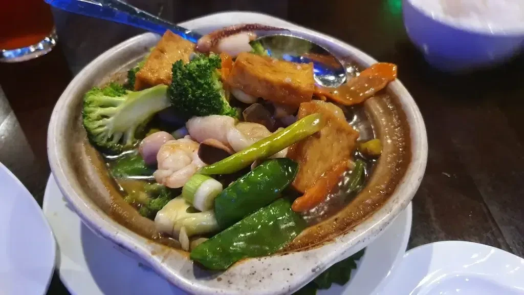 Colorful shrimp, broccoli, and tofu stir-fry served in a ceramic bowl.