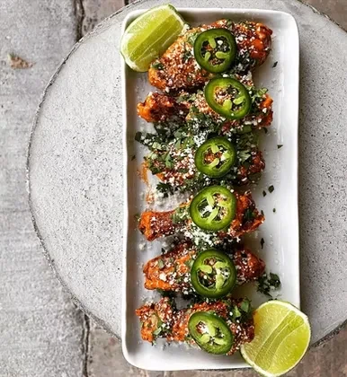 Seven sauced chicken wings, herbs, cheese, jalapeños, and lime.