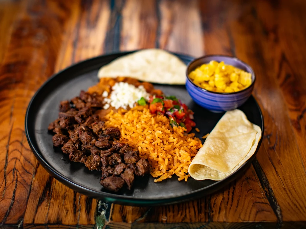 Plated meal: diced meat, orange rice, beans, pico, tortillas, and corn.