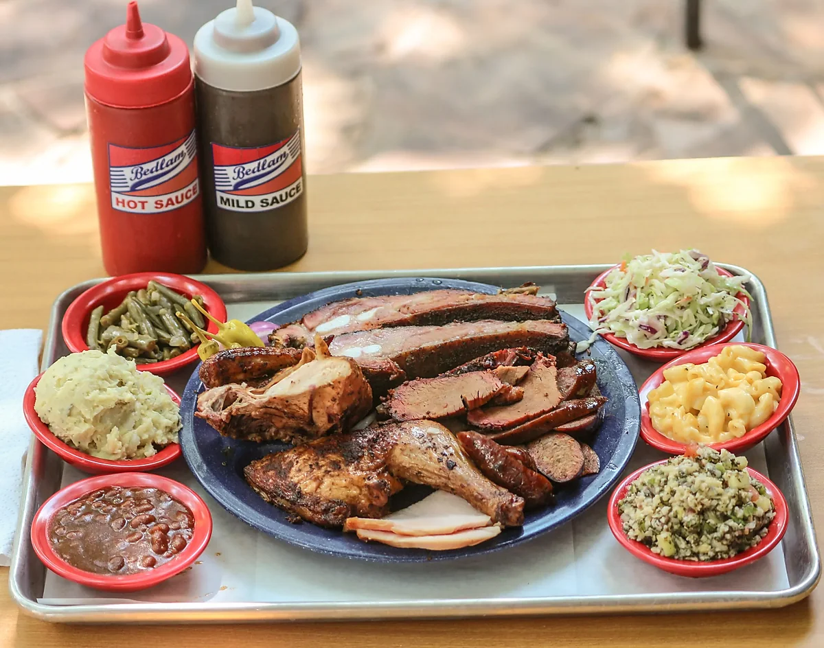 Barbecue platter with ribs, brisket, chicken, sausage and six sides