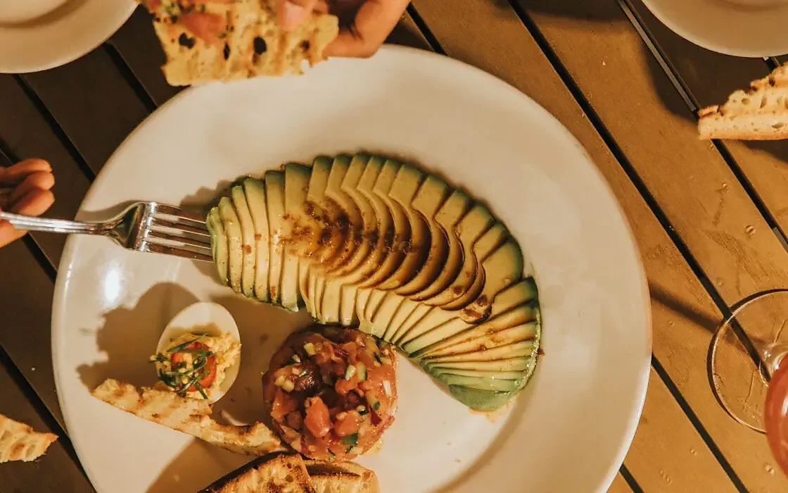 Tuna tartare with fanned avocado and toasted bread on plate