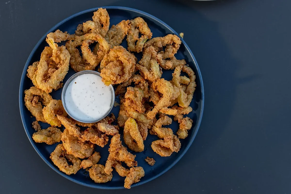 Fried banana peppers on blue plate with ranch dipping sauce