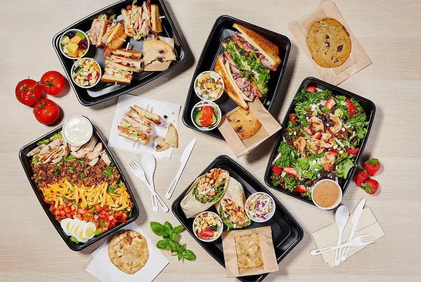 Overhead view: Assorted takeout meals including sandwiches, salads, and cookies.