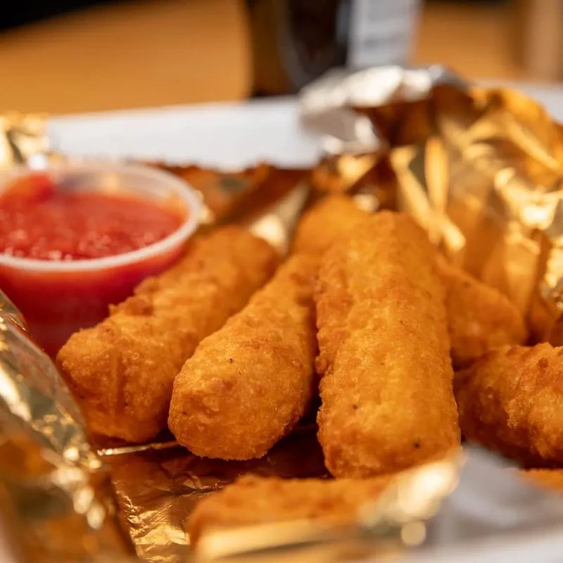 Golden-brown fried appetizers and marinara sauce in a foil-lined tray.