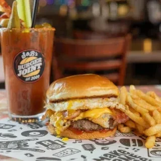 A stacked burger, fries, and Bloody Mary at JoJo's Burger Joint.