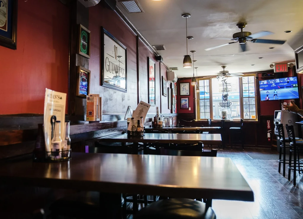 Empty bar or restaurant interior with red walls and wooden tables.