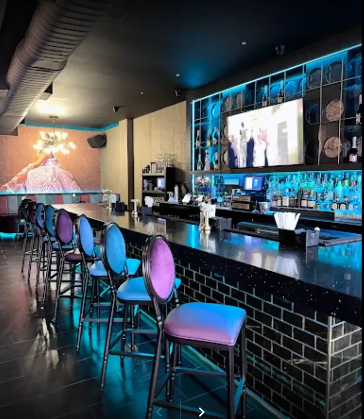 Empty bar with colorful stools and blue lights.