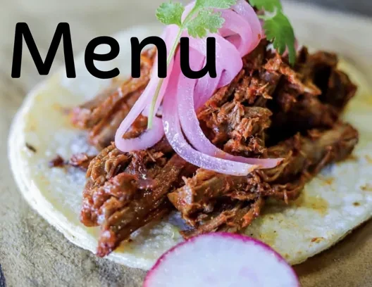 Menu written over a taco with meat, pickled onions, and cilantro.