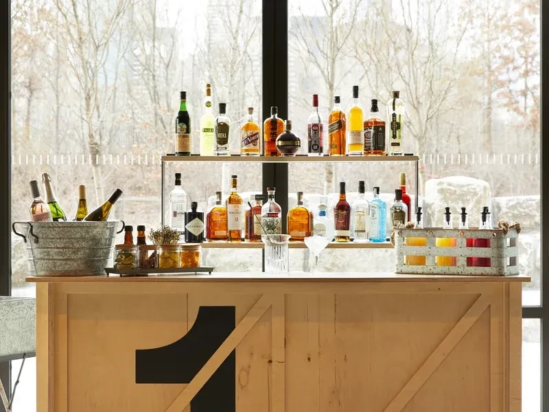 A wooden bar with various bottles of alcohol and mixers, number one visible.