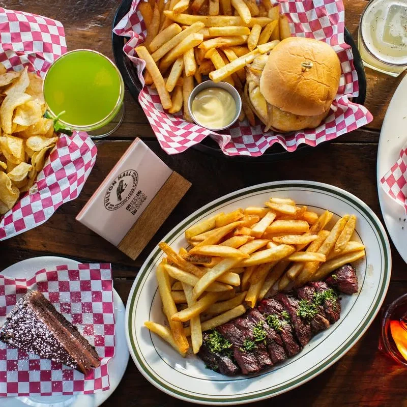 An overhead shot of a table with several fried dishes and drinks.