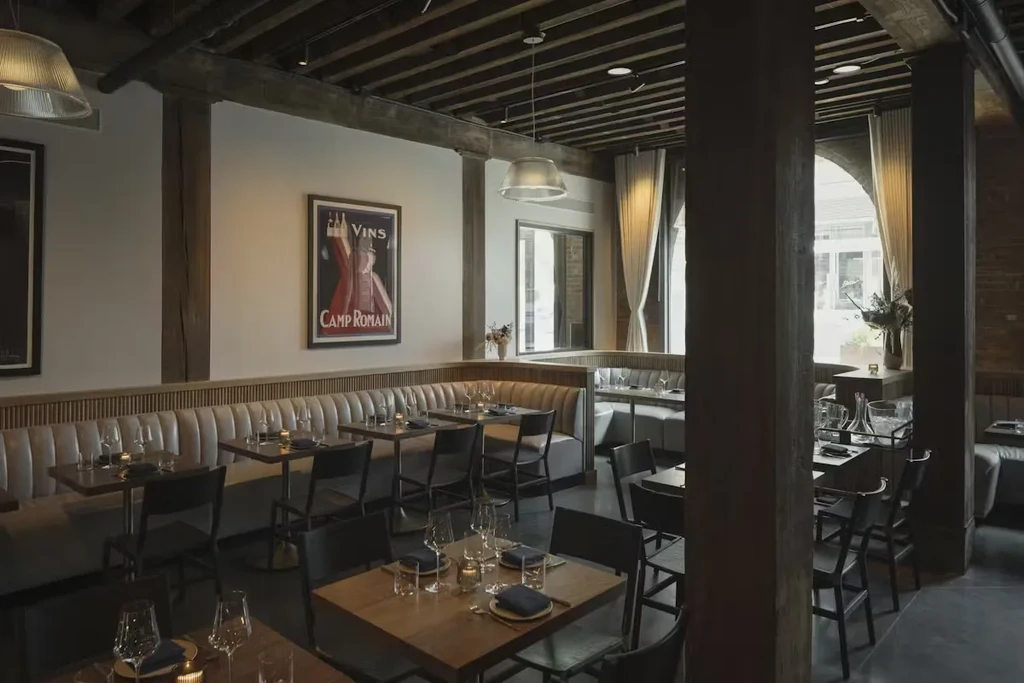 An empty modern restaurant with tables and booth seating and vintage posters.