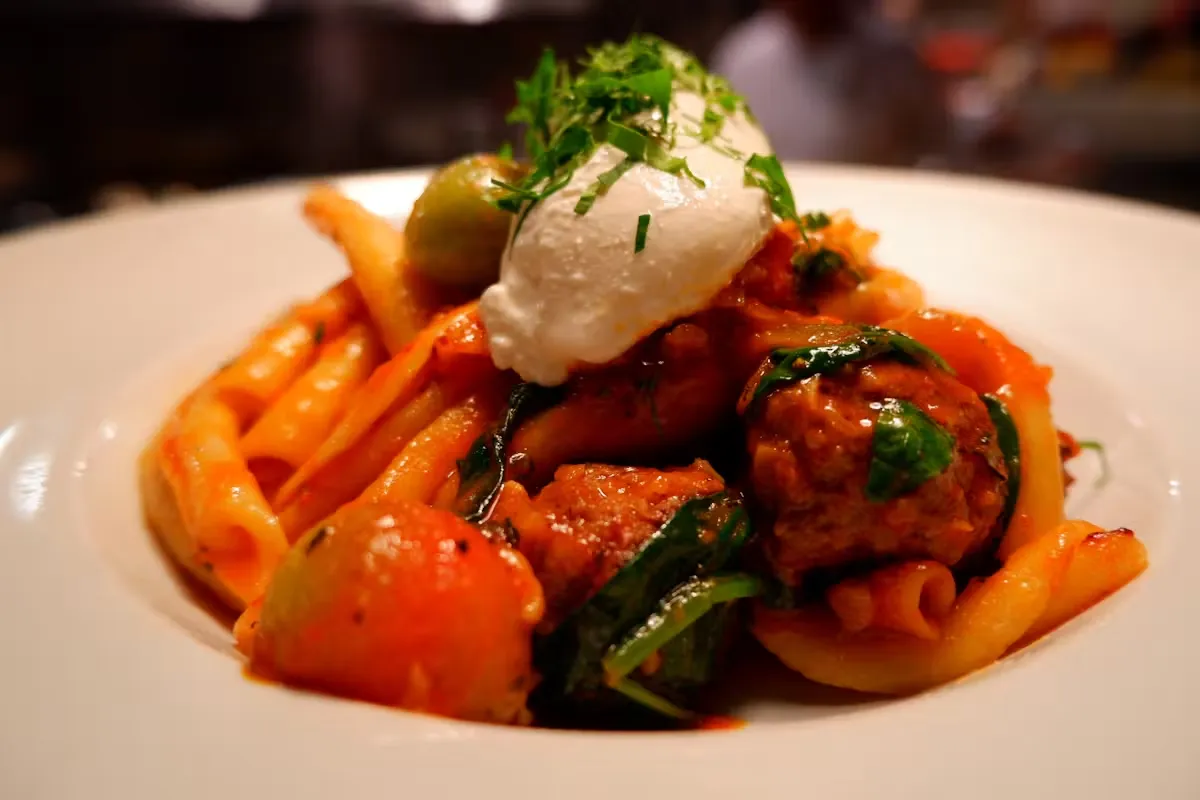Pasta with meatballs, tomato sauce, ricotta cheese, and spinach.