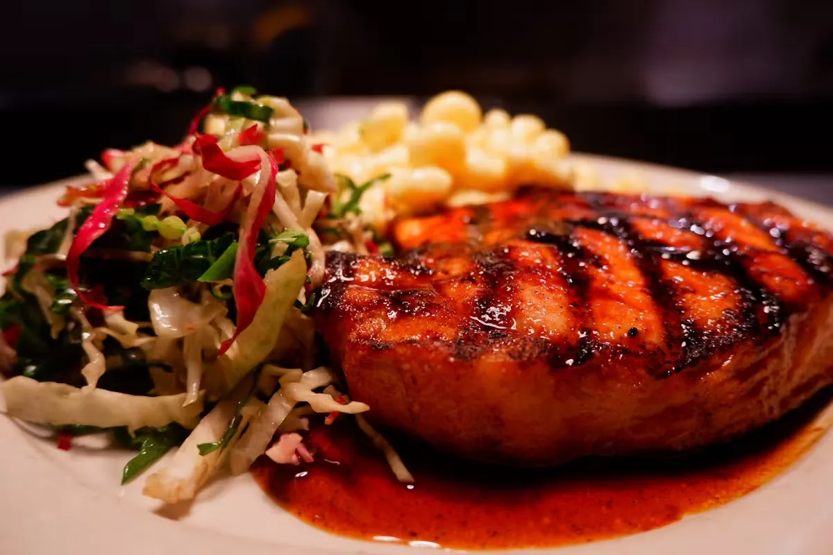Grilled salmon, coleslaw, and pasta salad on a white plate.