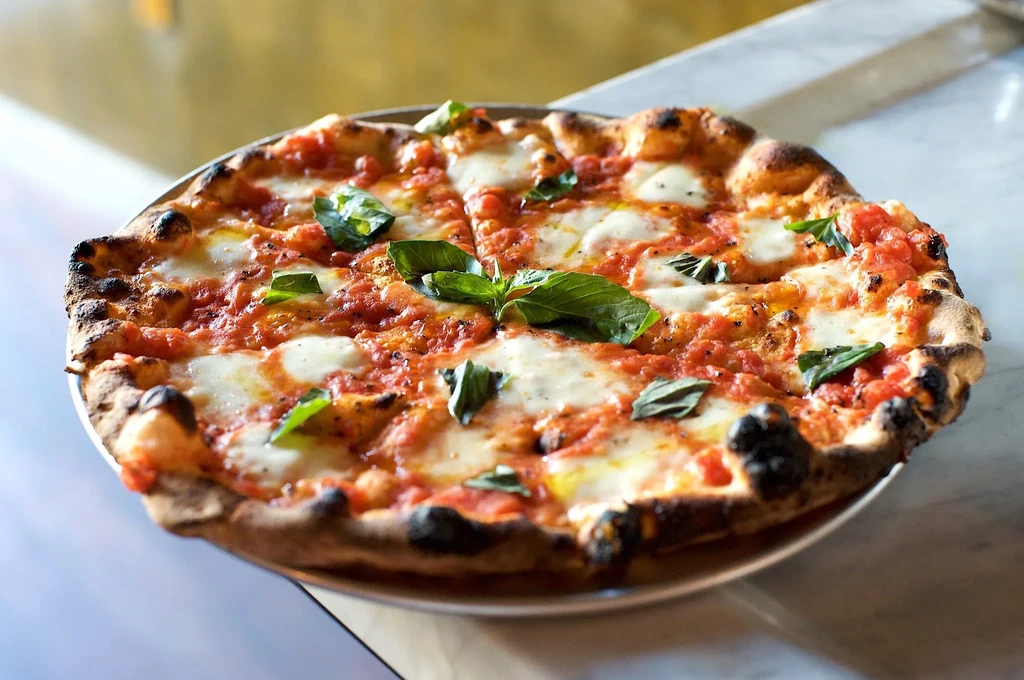 A fresh Neapolitan pizza with tomato sauce, mozzarella, and basil.