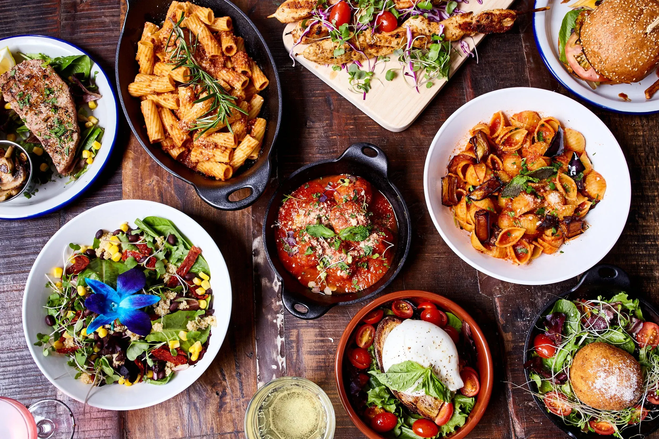 Assortment of Italian-inspired dishes and drinks on a rustic wooden table.