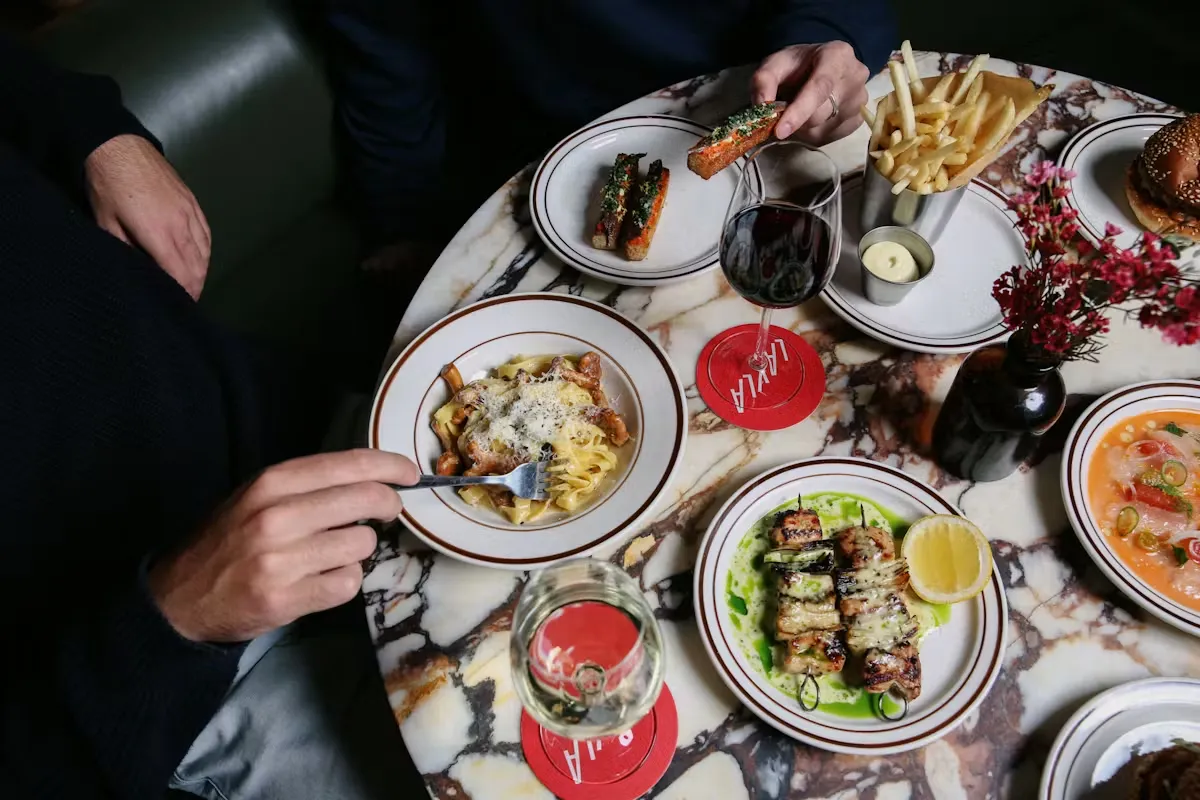 Overhead view of a marble table laden with various dishes and drinks.