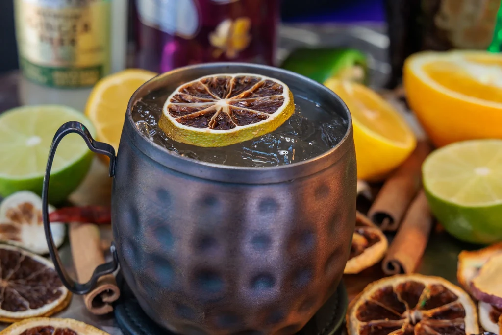 A bronze hammered mug with a drink and dried lime slice.