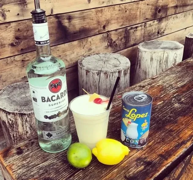 Pina Colada ingredients: rum, coconut cream, lime, lemon, and a drink.
