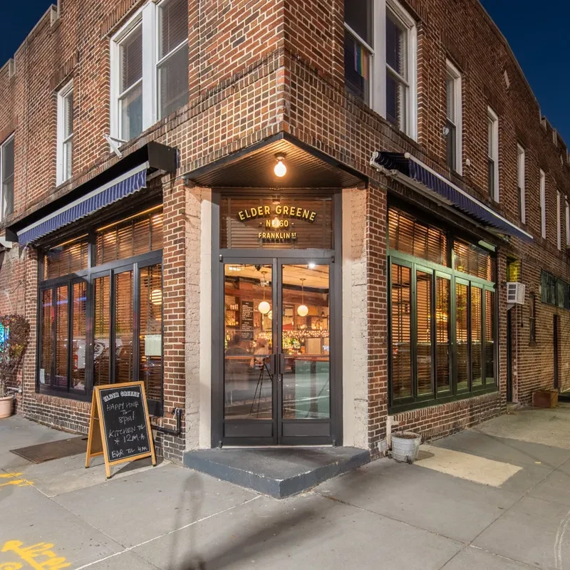 Exterior view of Elder Greene bar and restaurant at dusk.