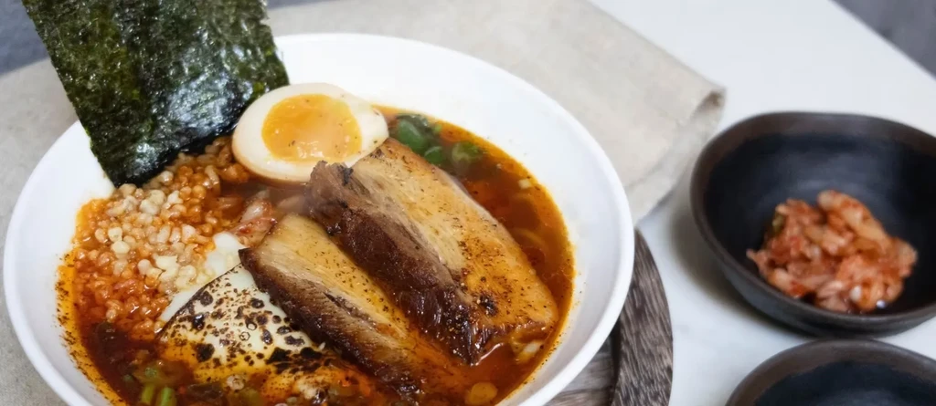 Spicy ramen with pork belly, soft-boiled egg, nori, and kimchi.