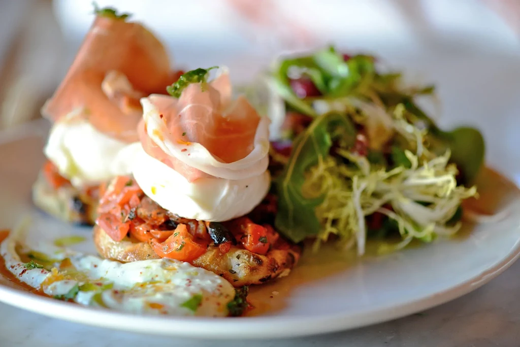 Bruschetta with prosciutto, mozzarella, chopped tomatoes, and a side salad.