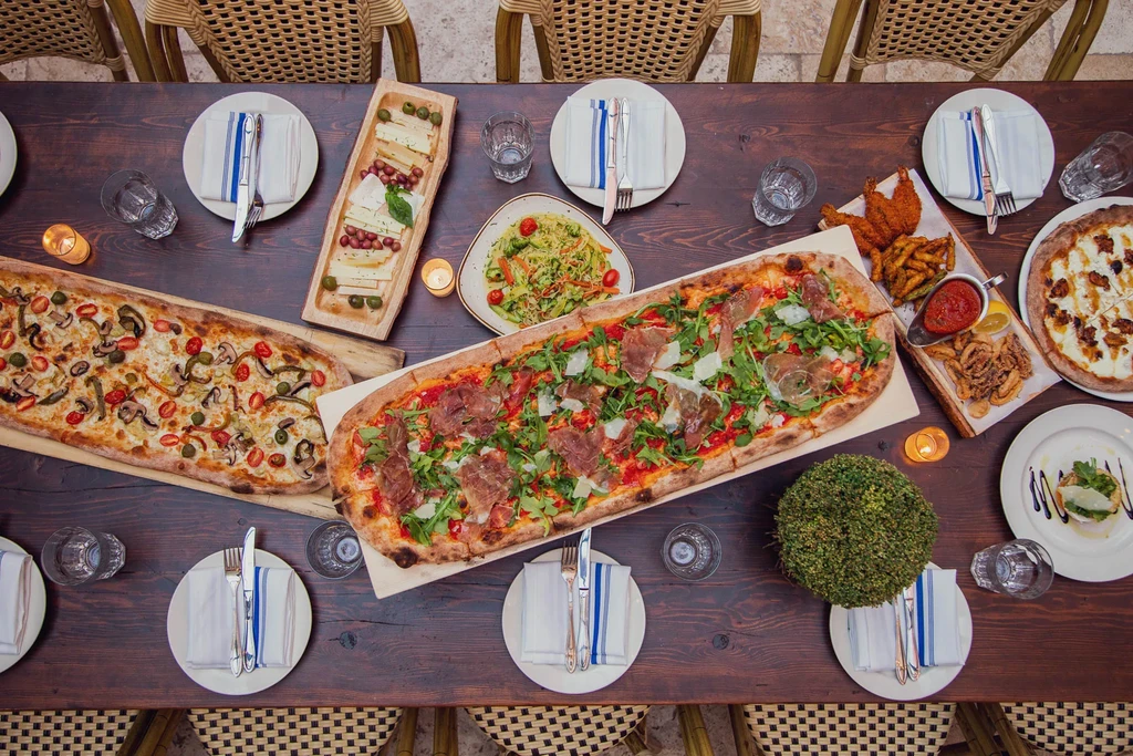 Overhead view of a dining table laden with various Italian dishes.
