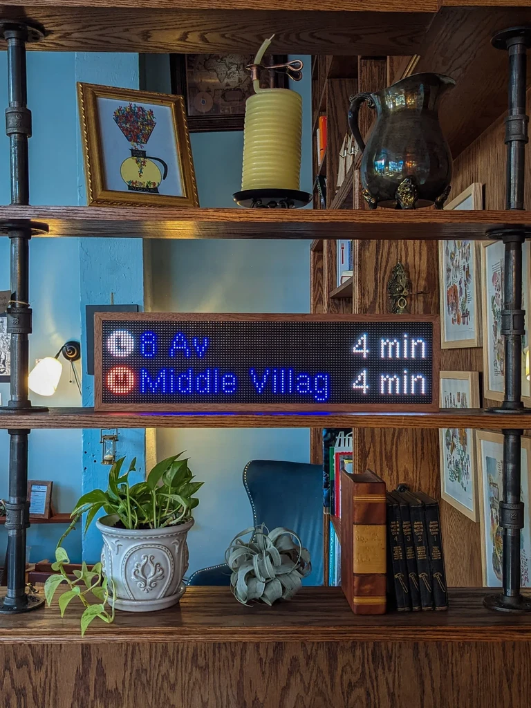 An LED subway sign displaying 8 Av and Middle Village, both 4 min.