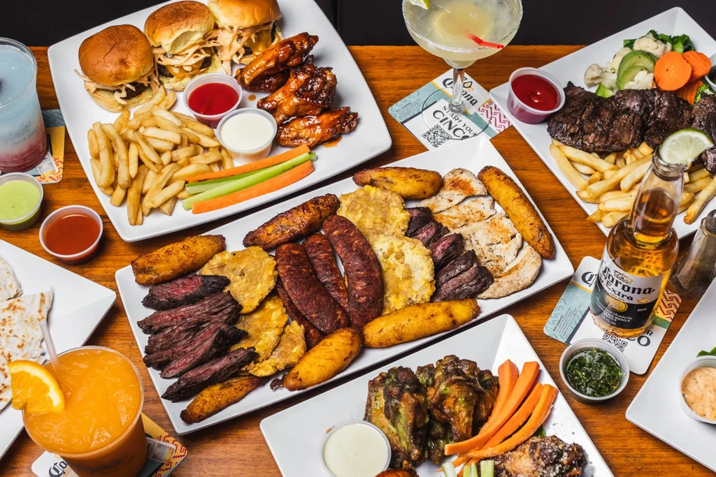 A table full of platters with Latin American food and drinks.