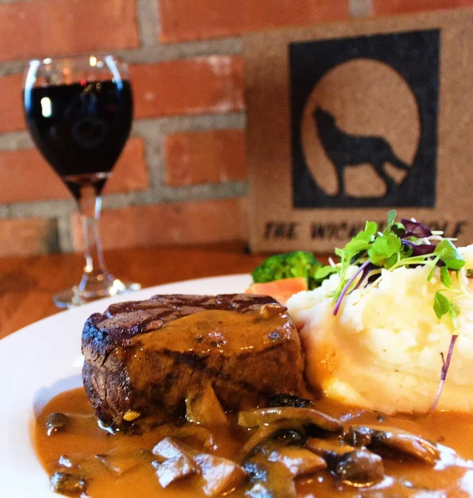 Steak with mushroom sauce, mashed potatoes, and red wine.